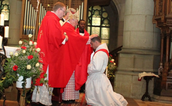 Bischof Ludwig Schwarz legt dem Priesterkandidaten bei der Priesterweihe im Linzer Mariendom die Hände auf. 